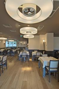 a dining room with tables and chairs and a large ceiling at Zen Hotel Versilia in Marina di Pietrasanta