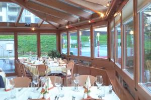 a dining room with tables and chairs and windows at HOTEL&RESTAURANT Rebstock Wolhusen in Wolhusen