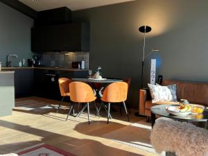 a kitchen and a living room with a table and chairs at Riddertunets toppleilighet in Beitostøl