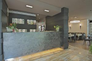 a bar in a restaurant with tables and chairs at Zen Hotel Versilia in Marina di Pietrasanta