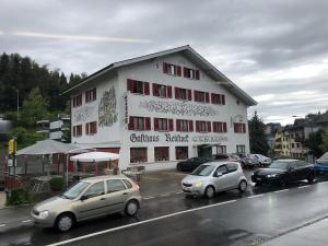 a building with cars parked in a parking lot at HOTEL&RESTAURANT Rebstock Wolhusen in Wolhusen +5 photos