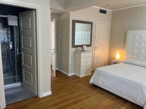 a bedroom with a bed and a mirror at Hotel 1908 in Forte dei Marmi