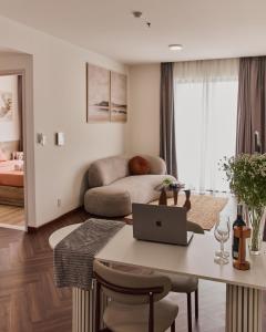 a living room with a table with a laptop on it at HongHome Compass One in Ga Phú Văn
