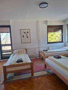 a room with three beds and two windows at Villa Sabic - Free Garage & Panoramic View in Sarajevo