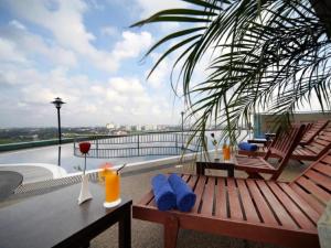 einen Balkon mit einem Tisch und Stühlen auf dem Dach in der Unterkunft Grand Paragon Hotel Johor Bahru in Johor Bahru