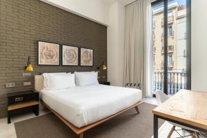 a bedroom with a white bed and a brick wall at Midtown Apartments in Barcelona +55 photos