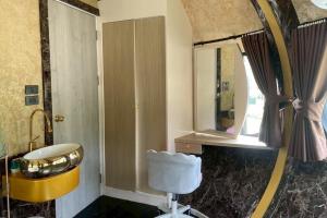 a bathroom with a mirror and a chair in it at Honey Queen Resort in Ban Tha Manao