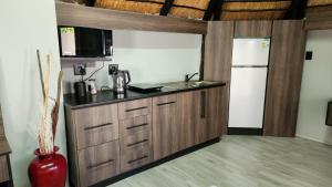 a kitchen with wooden cabinets and a counter top at Bootleg Inn in Welkom