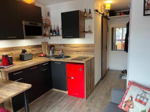 a kitchen with a red cabinet in a room at Ada & Cimes in Bourg-Saint-Maurice