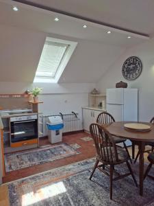 a living room with a table and a kitchen at Villa Sabic - Free Garage & Panoramic View in Sarajevo