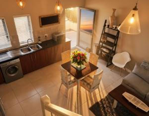 a kitchen and a living room with a table and chairs at 19 Lagoon Terrace in Knysna