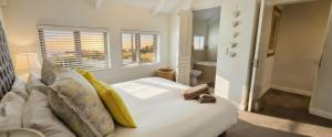 a bedroom with a large white bed with yellow pillows at 19 Lagoon Terrace in Knysna