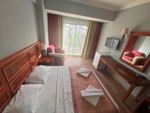 a hotel room with a bed and a mirror at Grand Nar Hotel ADULT ONLY - All Inclusive in Kemer