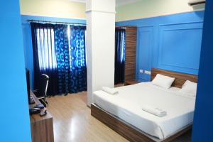 a bedroom with a bed with a blue wall at Royal Homes in Tallākulam