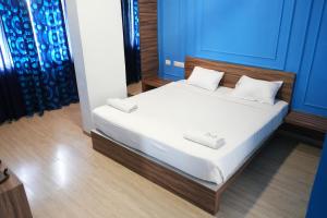 a bedroom with a bed with white sheets and pillows at Royal Homes in Tallākulam