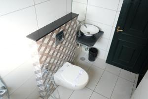 a small bathroom with a toilet and a sink at Royal Homes in Tallākulam