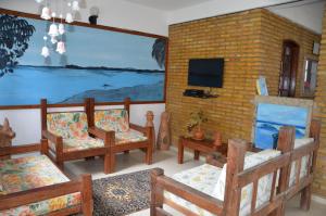 a living room with several chairs and a tv at Pousada Grauça in Cacha Pregos