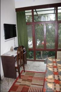een kamer met een bureau, een computer en een raam bij Homestay Chateau 39 in New Delhi