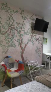 a room with a tree mural on the wall at Les Victoriennes in Verdun-sur-Meuse