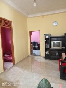 a living room with a tv and a tv stand at Jupe Homestay batukaras in Batukaras