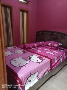 a bed with a hello kitty blanket on it at Jupe Homestay batukaras in Batukaras