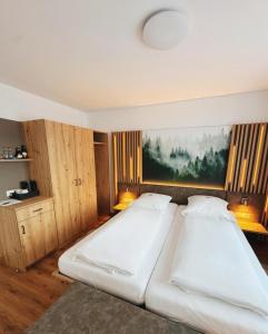 two beds in a bedroom with a painting on the wall at Hotel Waldeck mit Restaurant "Florian'S" in Feldberg