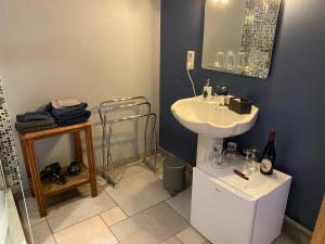 a bathroom with a white sink and a mirror at Forges de Pernelle in Couvin
