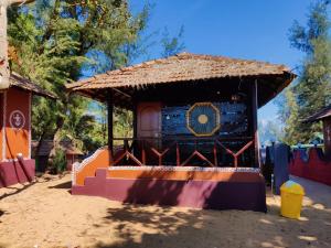 a small hut with a thatched roof at patanga beach cottege in Gokarna