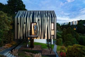 a small house with a striped roof in a garden at 1Step2AllStars Baumhaus in Wuppertal