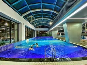 a large indoor swimming pool with blue water at Home MinMimi in Gia Lâm Pho