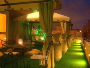 un patio con iluminación verde, mesa y sillas en Amaranto Hotel, en Afragola