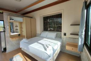 a bedroom with a large white bed and a window at Honey Queen Resort in Ban Tha Manao