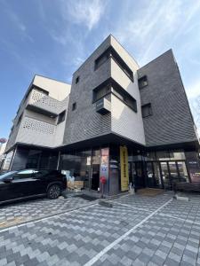 a black car parked in front of a building at Koin Guesthouse Incheon airport in Incheon
