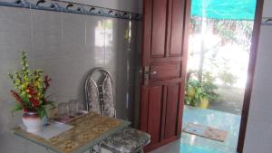 a room with a table and a door with a window at Thao Vi Guest House Duc Thao in Mui Ne