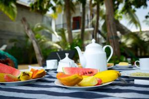 a table with two plates of fruit on it at Sunray Beach House in Tangalle