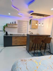 a kitchen with a island and a counter with chairs at Jacuzzi Apartman in Karuše +13 photos