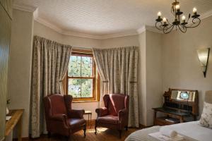 a bedroom with two chairs and a window at Haus Müller in Clanwilliam +59 photos