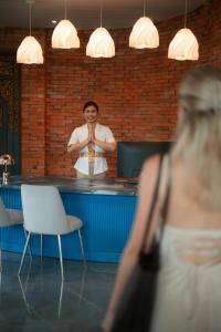 a woman is praying in front of a bar at Maca Villas & Spa Bali in Seminyak +39 photos