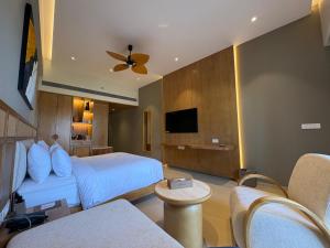 a hotel room with a bed and a tv at Peninsula Del Mar Beach Resort in Udupi