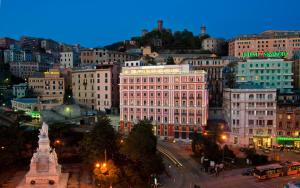 a view of a city at night with buildings at Grand Hotel Savoia in Genoa