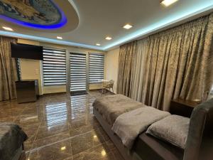 a bedroom with a bed and a tv and curtains at Imperia President in Paralia Katerinis
