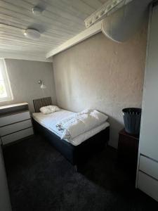 a small bedroom with a bed in the corner at Little House in Bäckaskog in Fjälkinge