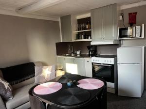 a small living room with a table and a kitchen at Little House in Bäckaskog in Fjälkinge