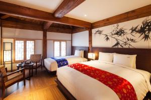 two beds in a room with wooden walls and wooden floors at Gyeongwonjae By Walkerhill in Incheon