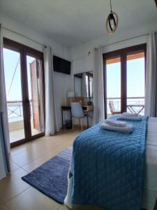 a bedroom with a blue bed with a view of the ocean at Bay blue in Pylos