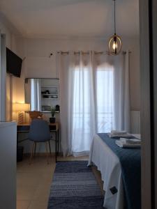 a bedroom with a bed and a desk and a window at Bay blue in Pylos