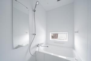 a white bathroom with a shower and a mirror at Stellavia in Nakafurano +93 photos