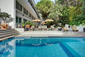 a pool at a hotel with chairs and umbrellas at Juliana Hotel Cannes in Cannes