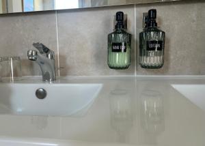 a bathroom sink with two bottles on the wall at Lésina Bed & Breakfast in Apt +17 photos