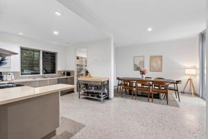 a kitchen with a table and a dining room at The Hideaway Currumbin in Gold Coast